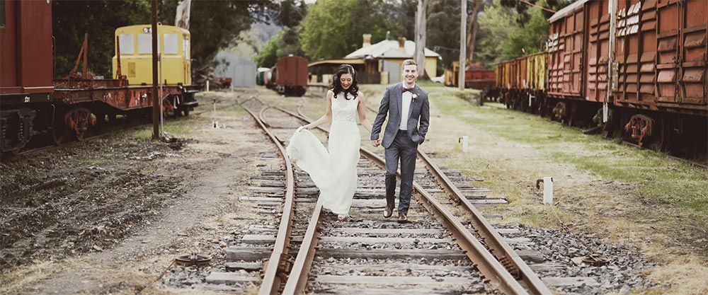 wedding couple walk on train tracks